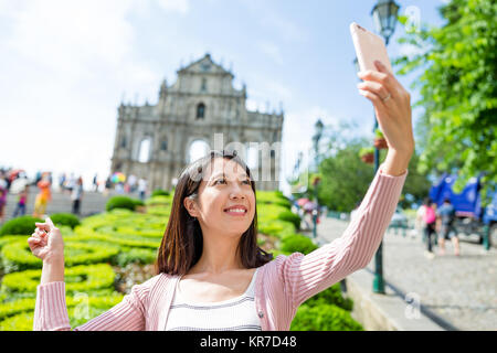 Young Woman taking selfie with Saint Paul's Cathedral in Macau Stock Photo