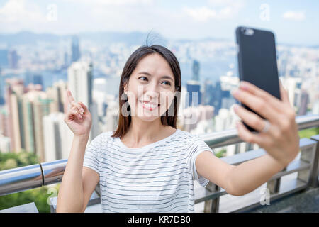 Woman taking selfie by cellphone in Hong Kong Stock Photo