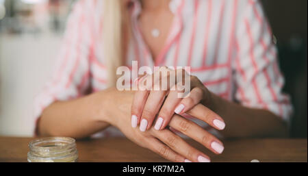 Middle-aged blond woman putting cosmetics Stock Photo