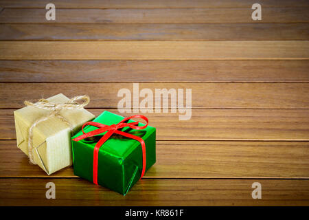 Metallic green and brown paper gift packages on a wooden background. Stock Photo