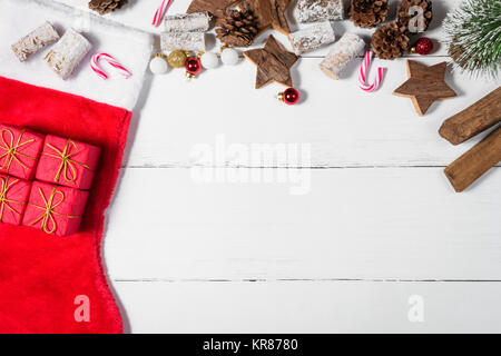 Christmas Stocking and Ornaments Spread Out over White Wooden Table Stock Photo