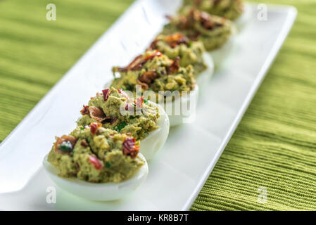 Bacon guacamole deviled eggs Stock Photo