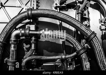 Fragment of modern technology. Details of engine pipelines. Black and white. Background. Stock Photo