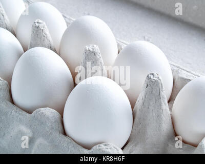 Fresh white raw eggs in shell eggs ready for cooking and diet food lie in an open cardboard container for carrying and storing eggs Stock Photo