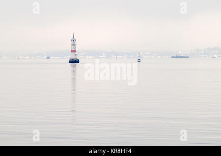 Calm and empty waters of Oslofjord fairways in winter foggy day, only with lighthouses and other navigational signs. Stock Photo