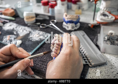 Dental technician applying ceramics Stock Photo