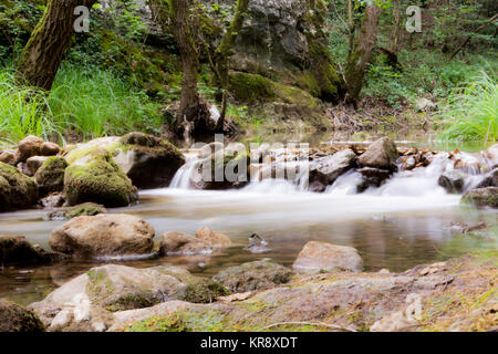 Water stream running over mossy rocks Stock Photo