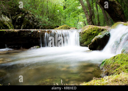 Water stream running over mossy rocks Stock Photo