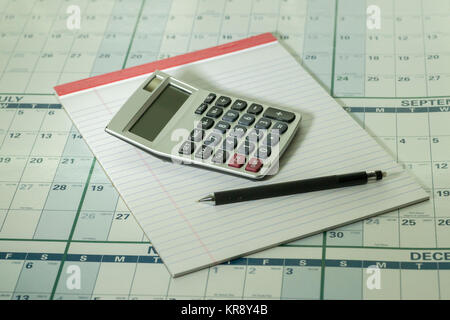 Calculator pad and pencil  on calandar background Stock Photo