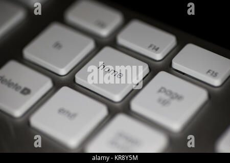 Closeup of home key on computer keyboard with white keys on dark background Stock Photo