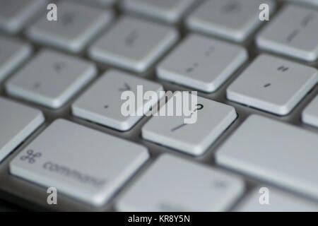 Closeup of question mark key on computer keyboard with white keys on dark background Stock Photo