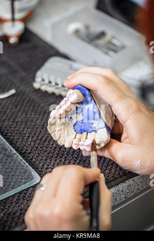 Dental technician applying ceramics Stock Photo