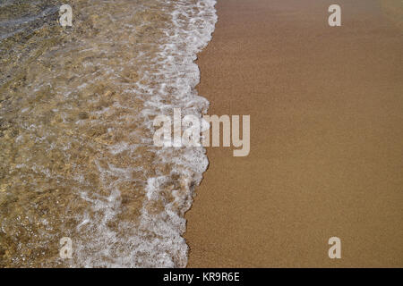 Waves lapping on the sandy shore Stock Photo