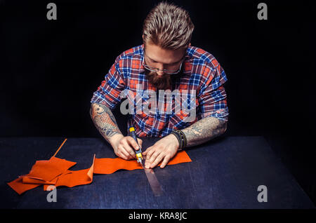 Leather Currier produce a leatherwork at his shop./Leather Professional producing a good product at workplace. Stock Photo