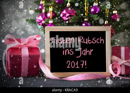 Chalkboard With German Text Guten Rutsch Ins Jahr 2017 Means Happy New Year. Christmas Tree With Rose Quartz Balls, Snowflakes And Bokeh Effect. Gifts Or Presents In The Front Of Cement Background. Stock Photo
