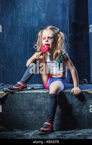 The crasy girl with candy on dark background Stock Photo