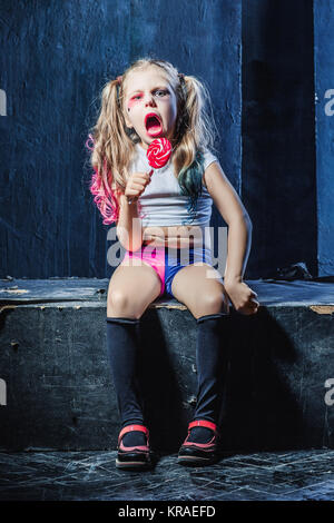 The funny crasy girl with candy on dark background Stock Photo