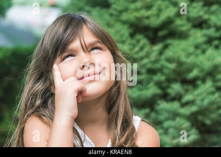 Little girl with long hair looks up Stock Photo
