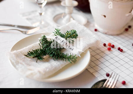 Christmas table: knife and fork, napkin and Christmas tree branch on a wooden table . New Year's decor of the festive table. Christmas background. Stock Photo