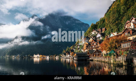 Scenic view of famous Hallstatt lakeside town reflecting in Hallstattersee lake in the Austrian Alps in morning light in autumn with clouds, Salzkamme Stock Photo