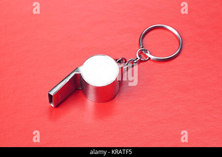 Sports or coaches metal whistle, closeup. Concept refereeing sport on red card background. Soccer or football referee whistle and caution cards Stock Photo