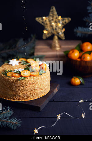 Christmas Honey cake with rosemary and oranges on black background.