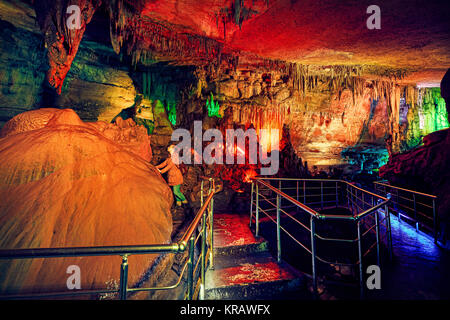 Tourist woman in underground cave Sataplia with colorful illumination in Kutaisi, Georgia Stock Photo