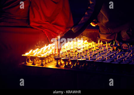 Monk fire the oil lamps of peace in the Buddhist Temple in Kathmandu Stock Photo