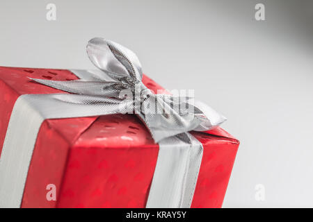 Christmas valentine or birthday red gift box with silver ribbon. Stock Photo