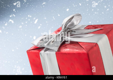 Christmas valentine or birthday red gift box with silver ribbon. Stock Photo