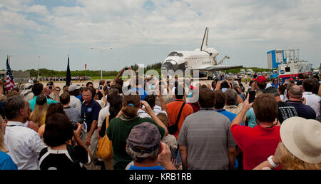 NASA employees and contractors crowd together to get a glimpse of space shuttle Atlantis (STS-135) as it rolls toward the Orbiter Processing Facility (OPF) at a wheels stop event, Thursday, July 21, 2011, at NASA's Kennedy Space Center in Cape Canaveral, Fla. Atlantis returned to Kennedy early Thursday following a 13-day mission to the International Space Station (ISS) and marking the end of the 30-year Space Shuttle Program. Overall, Atlantis spent 307 days in space and traveled nearly 126 million miles during its 33 flights. Atlantis, the fourth orbiter built, launched on its first mission o Stock Photo