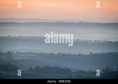 Mist hangs in the valleys as the sun rises over the Somerset Levels. Stock Photo
