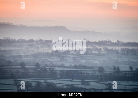 Mist hangs over frosty fields as the sun rises over the Somerset Levels. Stock Photo