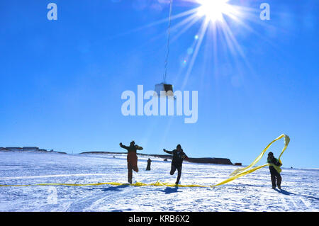 BARREL team members run under the payload as the balloon first takes flight at the SANAE IV research station in Antarctica.  Credit: NASA  ---  In Antarctica in January, 2013 – the summer at the South Pole – scientists launched 20 balloons up into the air to study an enduring mystery of space weather: when the giant radiation belts surrounding Earth lose material, where do the extra particles actually go? The mission is called BARREL (Balloon Array for Radiation belt Relativistic Electron Losses) and it is led by physicist Robyn Millan of Dartmouth College in Hanover, NH. Millan provided photo Stock Photo