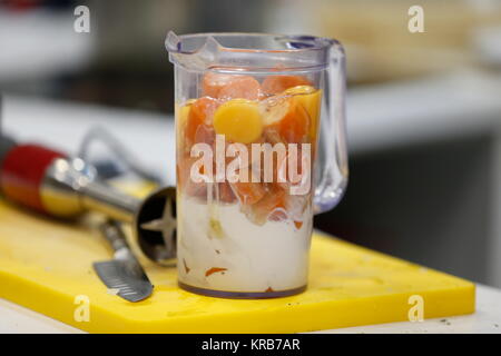 In a glass of boiled carrots and eggs.Carrot and milk in a blender. Mix the ingredients Stock Photo