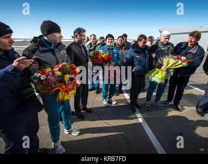 Expedition 34 Russian Flight Engineer Evgeny Tarelkin, left with flowers, Flight Commander Kevin Ford of NASA, center with flowers, and Russian Soyuz Commander Oleg Novitskiy are greeted at the Kustanay Airport a few hours after they landed near the town of Arkalyk, Kazakhstan on Saturday, March 16, 2013. Ford, Novitskiy, and Tarelkin are returning from 142 days onboard the International Space Station where they served as members of the Expedition 33 and 34 crews. Photo Credit: (NASA/Bill Ingalls) Soyuz TMA-06M crew members are greeted at the Kustanay Airport Stock Photo