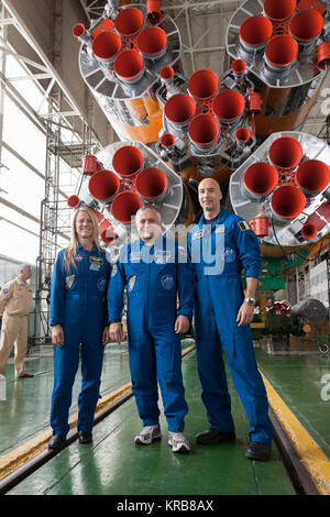 At the Baikonur Cosmodrome in Kazakhstan, Expedition 36/37 Flight Engineer Karen Nyberg of NASA (left), Soyuz Commander Fyodor Yurchikhin (center) and Flight Engineer Luca Parmitano of the European Space Agency (right) pose for pictures May 24 in front of the first stage engines of their Soyuz rocket in the Integration Facility following the final “fit check” dress rehearsal by the prime and backup crews. Nyberg, Yurchikhin and Parmitano  are preparing for launch May 29, Kazakh time, in the Soyuz TMA-09M spacecraft to begin a 5 ½ month mission on the International Space Station.  NASA/Victor Z Stock Photo