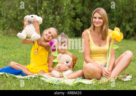 Mother and daughter sitting with soft toys on a picnic Stock Photo