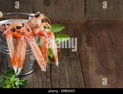 Raw langoustine in a bucket with herbs Stock Photo