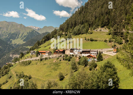 Little settlement of alpine huts and forests on the mountain Stock Photo