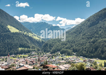The village in the mountains with green fields, meadows and forests Stock Photo