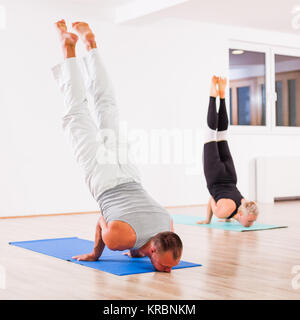 Adult man and woman practicing yoga, Mayurasana / Peacock pose Stock Photo