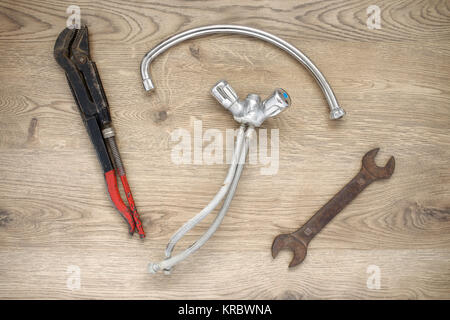 Old plumbing tools and tap on wooden background Stock Photo