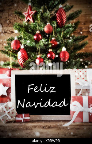 Christmas Card For Seasons Greetings. Christmas Tree With Balls. Gifts Or Presents In The Front Of Wooden Background. Chalkboard With Spanish Text Feliz Navidad Means Merry Christmas Stock Photo