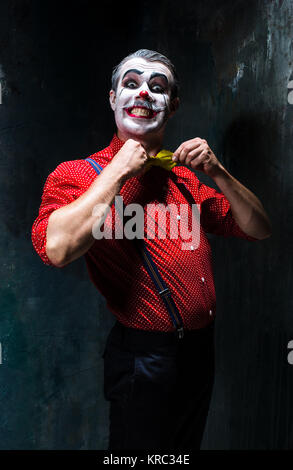 Terrible clown and Halloween theme: Crazy red clown in a shirt with suspenders Stock Photo