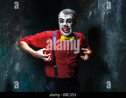 Terrible clown and Halloween theme: Crazy red clown in a shirt with suspenders Stock Photo