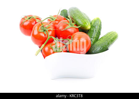 Fresh cucumbers and tomatoes in a white bowl Stock Photo