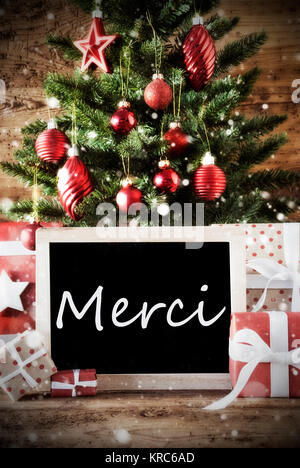 Christmas Card For Seasons Greetings. Christmas Tree With Balls. Gifts Or Presents In The Front Of Wooden Background. Chalkboard With French Text Merci Means Thank You Stock Photo
