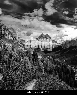 Dynamic surreal clouds running over the Tre Cime di Lavaredo, in the Italian Alps black and white Stock Photo