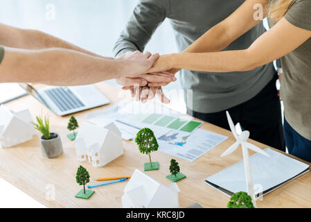 Smart team of engineers shaking hands after finishing a difficult project Stock Photo